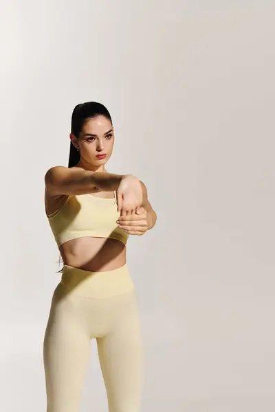 Mujer enérgica en equipo de fitness se estira para mejorar la flexibilidad y el atletismo. — Stock Photo