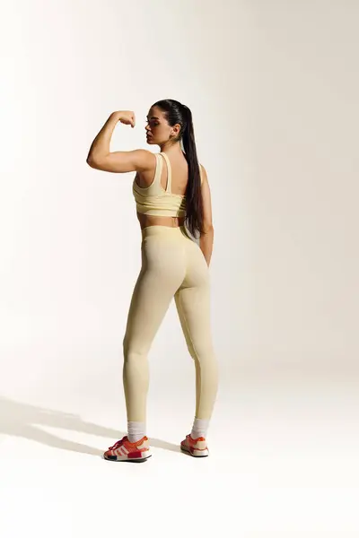 Mujer deportiva demuestra fuerza y confianza con una pose empoderada y ropa deportiva con estilo - foto de stock
