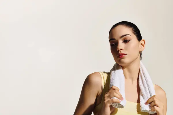 Una mujer hermosa y deportiva se relaja con una toalla alrededor de su cuello, irradiando confianza. — Stock Photo