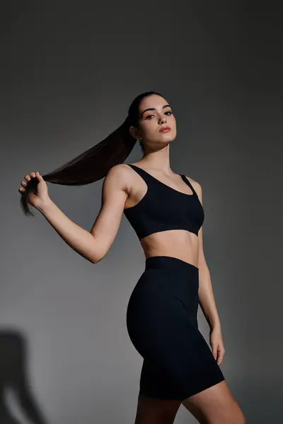 A young, athletic woman showcases her strength and grace while posing with confidence. — Stock Photo