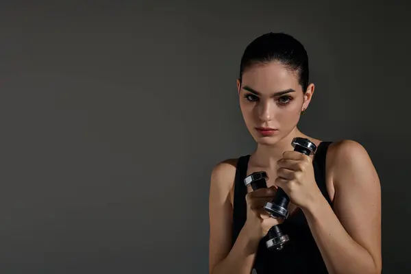 Fit young woman lifts weights, showcasing confidence and focus in her workout. — Stock Photo