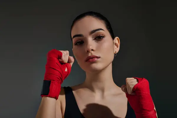Mujer joven decidida muestra su espíritu atlético con envolturas de boxeo para el entrenamiento. - foto de stock