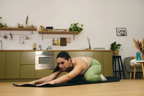 Sporty woman engages in a focused yoga session on a mat in a modern, cozy environment. — Stock Photo