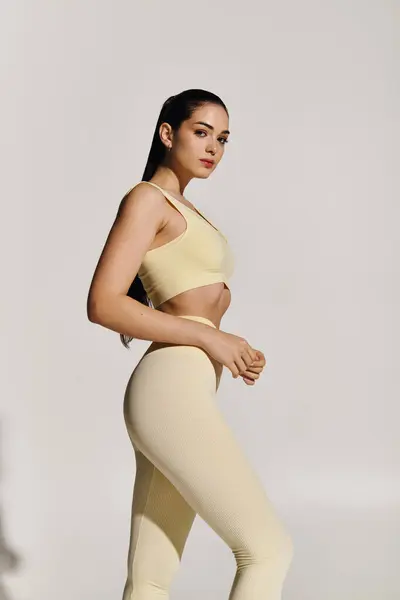 Una hermosa joven con una construcción atlética posa con confianza en atuendo deportivo, exudando energía. - foto de stock