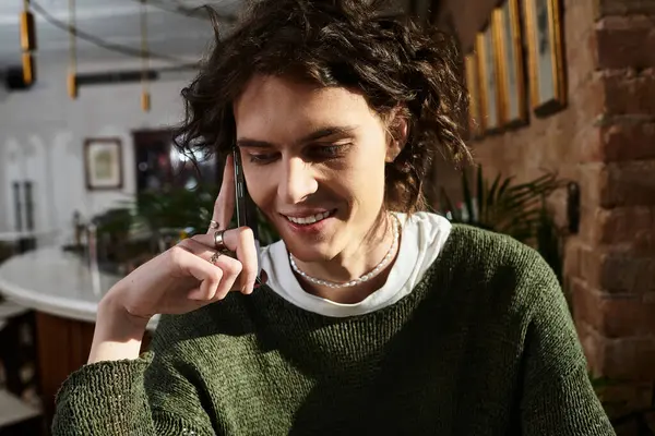 Handsome guy relaxes in a trendy cafe, chatting casually on the phone. — Stock Photo