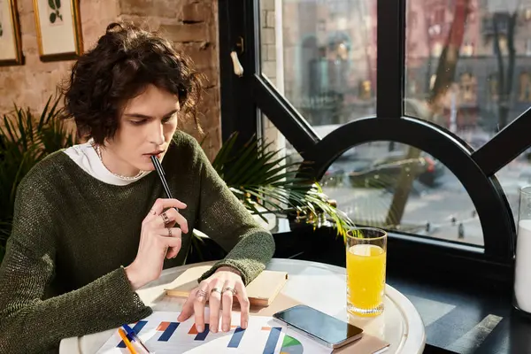 Young man sits at a cozy cafe, thoughtfully pondering while experimenting with creative concepts. — Stock Photo