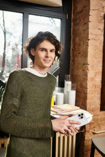 Gleeful young gentleman engages with his smartphone while savoring his time in a cafe. — Stock Photo