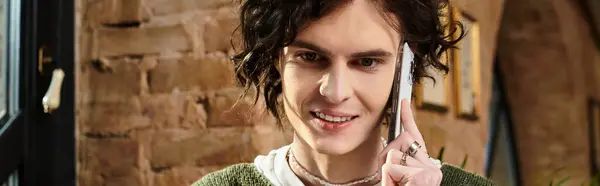 Un joven guapo se relaja en un café, entablando una animada conversación telefónica con una sonrisa. — Stock Photo