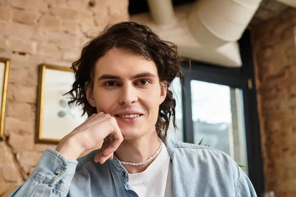 Ein gutaussehender junger Herr sitzt in einem gemütlichen Café und strahlt Glück und Charme aus, während er sich entspannt. — Stockfoto