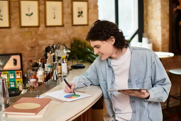 A young handsome guy relaxes at a charming cafe, jotting down notes and ideas on colorful papers. — Stock Photo