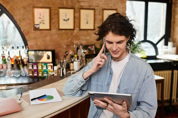 A stylish young man at a cafe interacts on his tablet while enjoying a relaxing afternoon. — Stock Photo