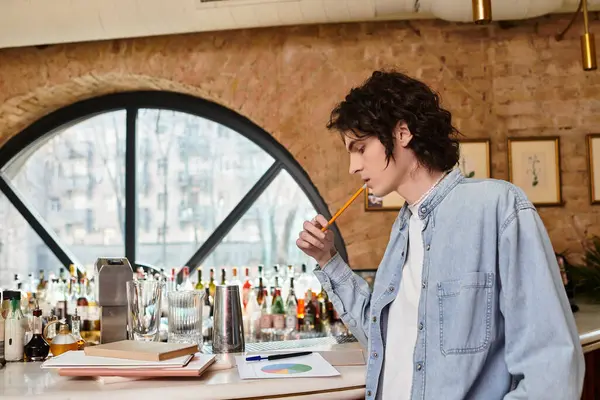Young man enjoys leisure time at a trendy cafe while contemplating his work and sipping a drink. — Stock Photo