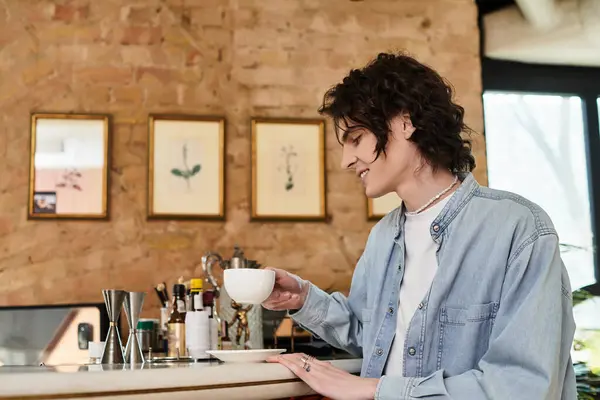 A young handsome man enjoys his coffee at a stylish cafe, radiating a calm vibe and leisure. — Stock Photo