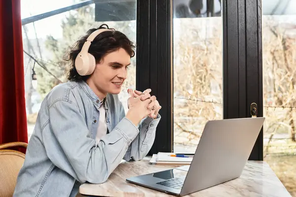 A handsome young man relaxes at a cafe, absorbed in his laptop and leisure activities. — Stock Photo