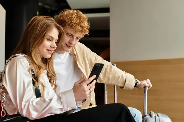 Loving couple shares laughter while exploring their latest travel memories in a chic hotel lounge. — Stock Photo