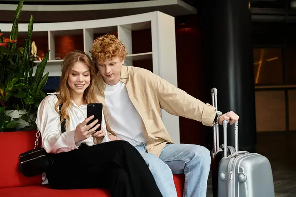 A beautiful couple enjoys a lighthearted moment while relaxing in a vibrant hotel setting. — Stock Photo