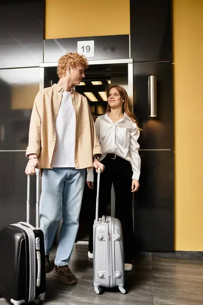 A young couple shares a loving glance in a hotel elevator, ready for a new adventure together. — Stock Photo
