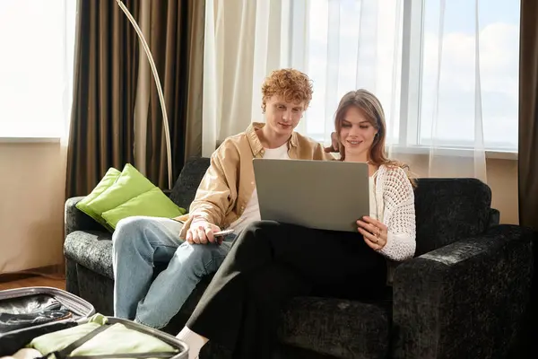 Two young lovers share a joyful moment as they explore together in their stylish hotel room. — Stock Photo