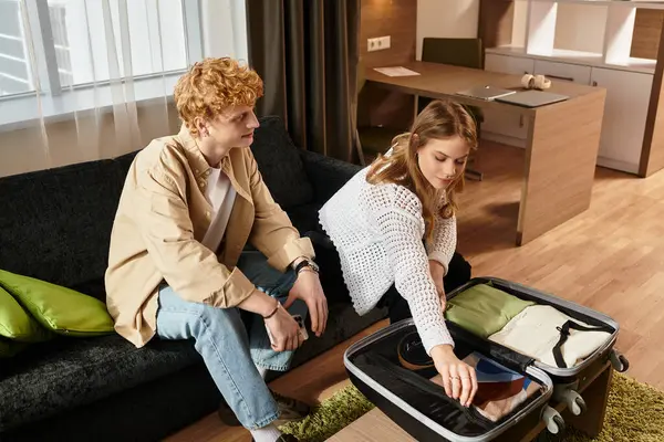 A young couple enjoys leisure time in their hotel room as they unpack and relax together. — Stock Photo