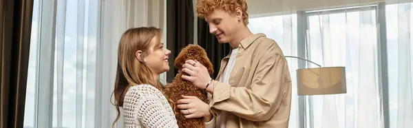 A loving couple shares a tender moment in their hotel room while cuddling their cute dog. — Stock Photo
