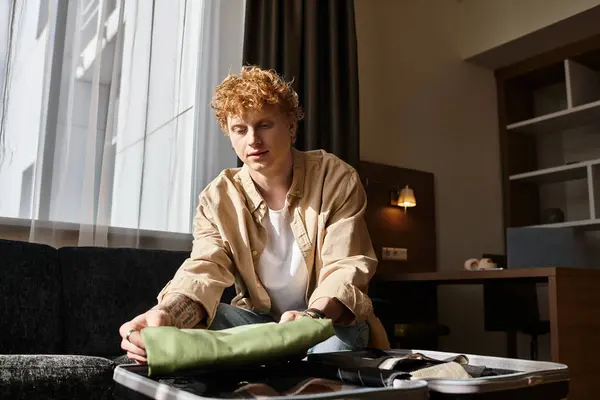 A man unpacking his belongings in a cozy hotel room. — Stock Photo