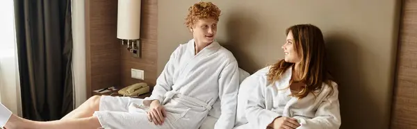 Romantic encounter of a young couple relaxing in a hotel room, sharing smiles and warmth. — Stock Photo