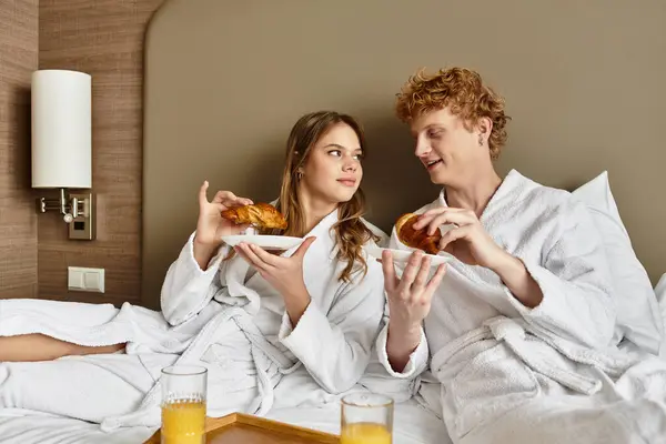 A loving young couple shares breakfast in a hotel room, creating intimate moments and joy. — Stock Photo