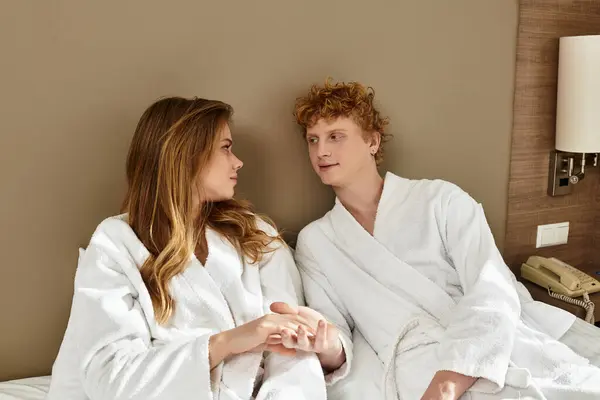 Two young lovers share a tender moment in their hotel room, surrounded by warmth and affection. — Stock Photo