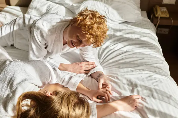 Un jeune couple partage un moment intime dans une chambre d'hôtel élégante avec des gestes ludiques et des sourires. — Photo de stock