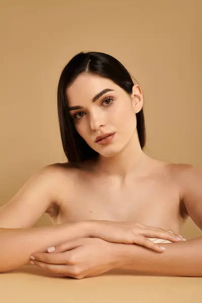 Giovane donna mette in mostra la pelle incredibilmente sana in un ambiente di studio ben illuminato, irradiando bellezza. — Foto stock