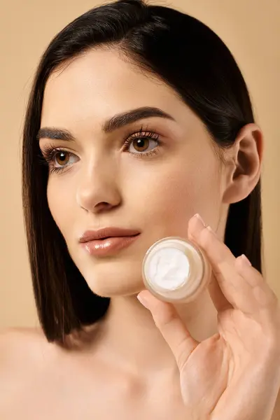 Young woman displays her healthy skin while promoting skin care in a studio environment. — Stock Photo
