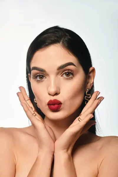 A stunning young woman flaunts bold red lips and elegant makeup, radiating confidence. — Stock Photo