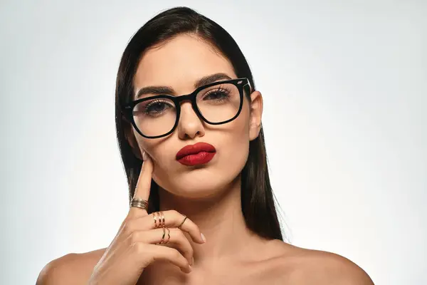 A confident young woman with red lips and glasses exudes charm and elegance. — Stock Photo
