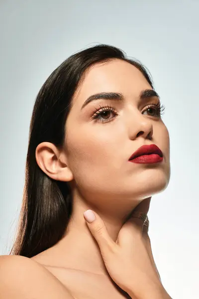 A captivating young woman with brown hair and striking red lips exudes elegance and charm. — Stock Photo