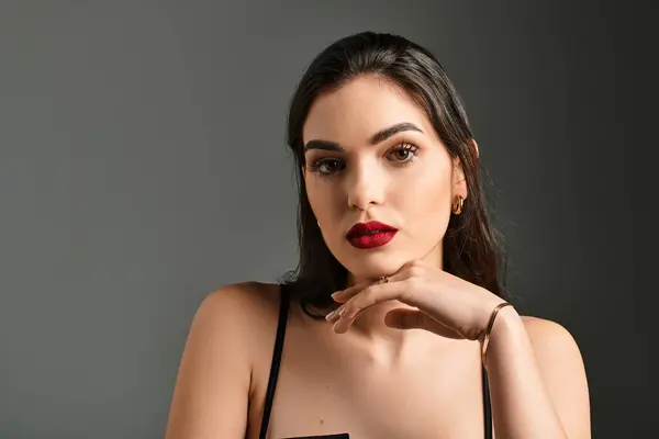 A beautiful young woman showcases her stunning brown hair and red lips, exuding confidence. — Stock Photo
