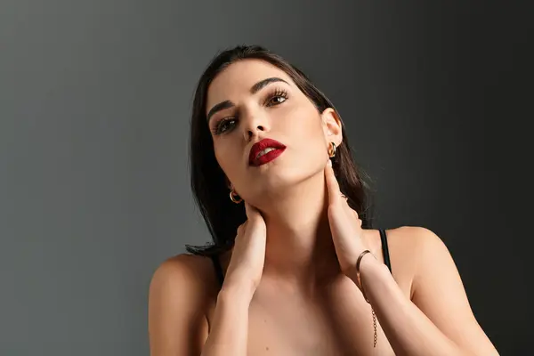 A young woman with brown hair poses gracefully, highlighting her red lips and flawless makeup. — Stock Photo