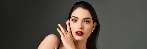 A stunning young woman poses gracefully with brown hair and bold red lips, radiating elegance, banner — Stock Photo