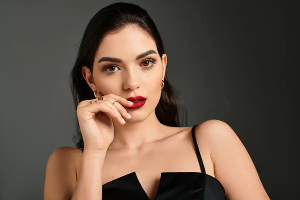 A young woman with brown hair poses elegantly, showcasing vibrant red lips and flawless makeup. — Stock Photo