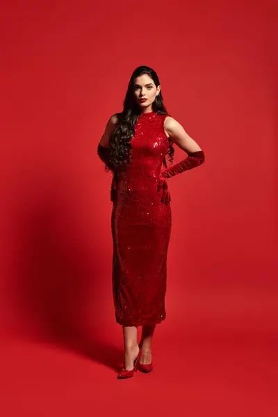 Uma bela jovem está de pé em um vestido vermelho vibrante, mostrando sua elegância e confiança. — Fotografia de Stock