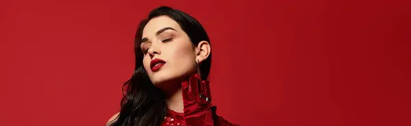 A beautiful young woman showcases her makeup in a vibrant studio with a striking red backdrop, banner — Stock Photo