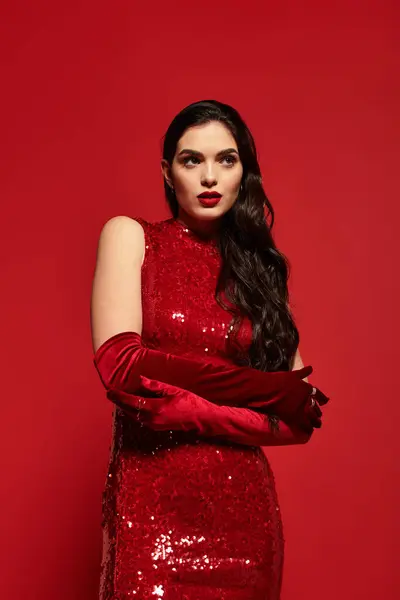 A young woman with brown hair showcases stunning red lipstick and elegant red gloves while posing. — Stock Photo