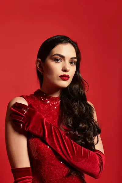 A young woman with captivating features and red lips stands gracefully, showcasing her glamour. — Stock Photo