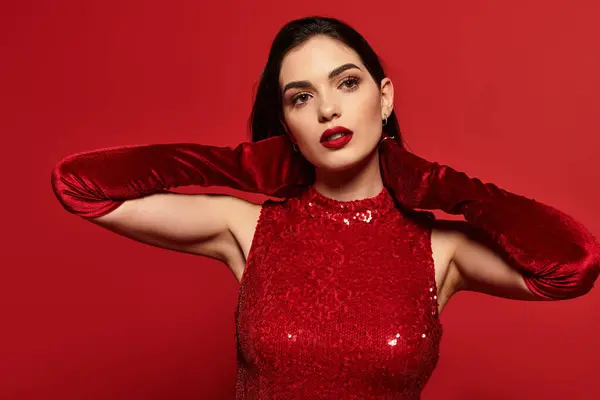 A young woman with striking red lips showcases her elegance while posing confidently in a studio. — Stock Photo