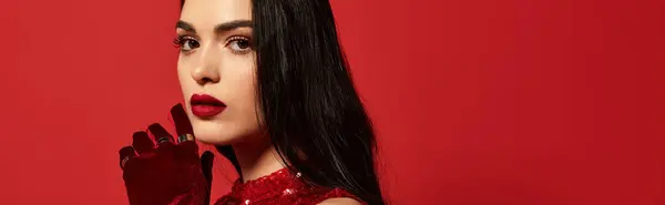 A young woman showcases her beauty in a vibrant red studio, featuring striking makeup and style, banner — Stock Photo