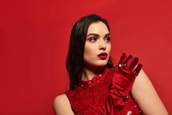 A stunning young woman with captivating red lips gazes thoughtfully in a vivid studio atmosphere. — Stock Photo