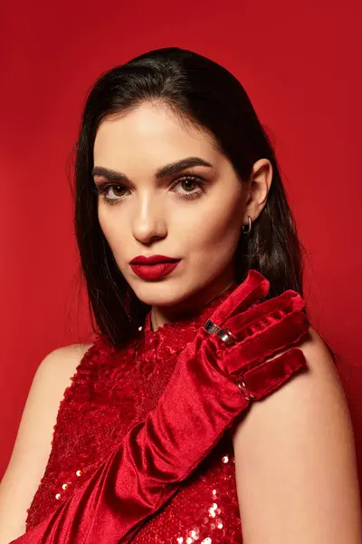 A captivating young woman with red lips poses elegantly in a studio, radiating confidence and charm. — Stock Photo
