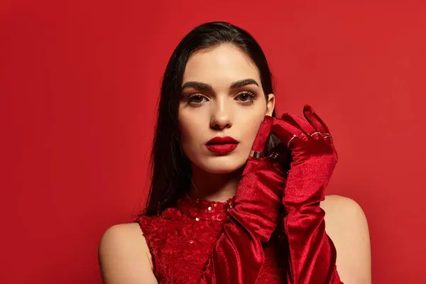 A confident young woman with striking red lips poses against a bold backdrop, radiating allure. — Stock Photo
