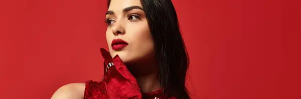 A beautiful young woman with red lips poses elegantly against a vibrant red backdrop, banner — Stock Photo