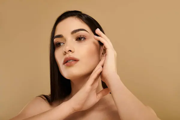 Une jeune femme à la peau rayonnante pose gracieusement dans un studio, incarnant beauté et santé. — Photo de stock