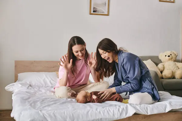 Two mothers share a moment of joy while playing with their child on mothers day at home. — Stock Photo